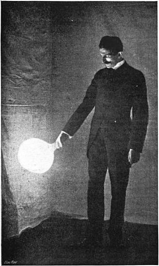 Tesla holding an illuminated bulb.
