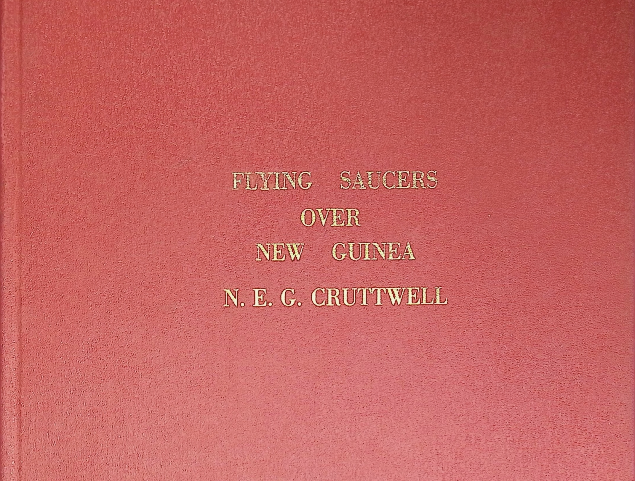 Red bound cover of Flying Saucers Over New Guinea by N.E.G. Cruttwell, gold embossed lettering