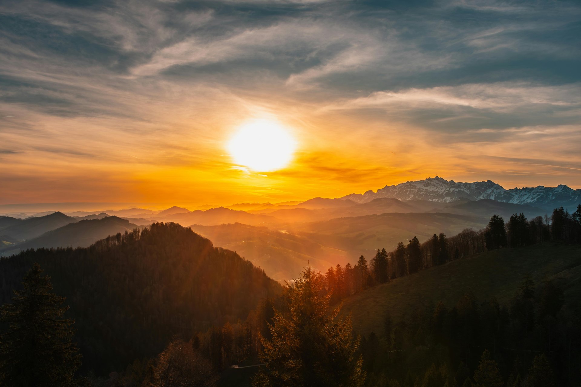 A calm sunrise over layered mountain ridges.